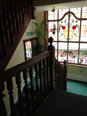 a staircase with a window and a chandelier at The Breverton in Lytham St Annes