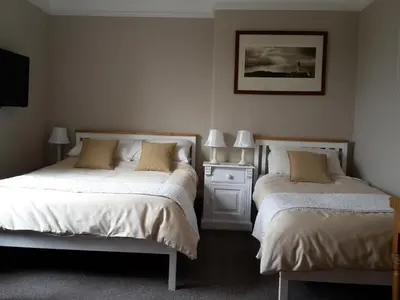 a bedroom with two beds and a picture on the wall at The Breverton in Lytham St Annes