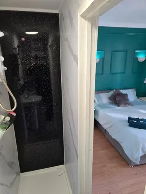 a bedroom with a bed and a bathroom with a mirror at Spacious Double Room in Anfield in Liverpool