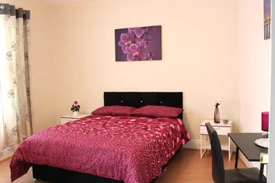 a bedroom with a bed with a red comforter at Spacious Double Room in Anfield in Liverpool