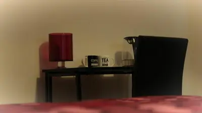 a table with a red lamp and a cup on it at Spacious Double Room in Anfield in Liverpool