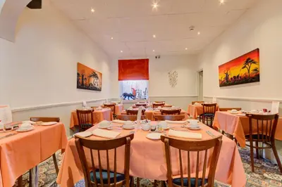 a dining room with tables and chairs with orange tablecloths at The Strathdon in Blackpool