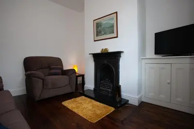 a living room with a chair and a fireplace at Spacious 3 bedroom Cottage in Whalley in Whalley