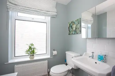a bathroom with a toilet and a sink and a window at Spacious 3 bedroom Cottage in Whalley in Whalley