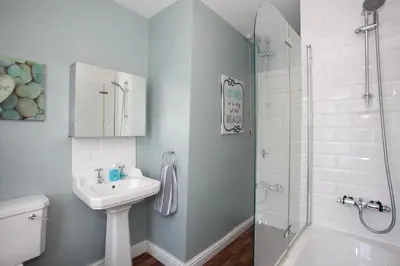 a white bathroom with a sink and a shower at Spacious 3 bedroom Cottage in Whalley in Whalley