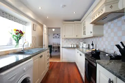 a kitchen with white cabinets and a sink and a window at Spacious 3 bedroom Cottage in Whalley in Whalley