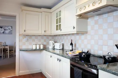 a kitchen with white cabinets and a counter top at Spacious 3 bedroom Cottage in Whalley in Whalley