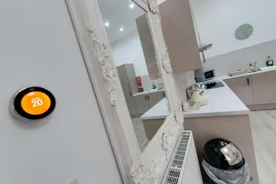 a mirror in a white kitchen with a sink at RST Rodney Street in Liverpool
