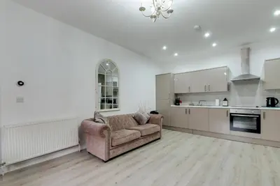 a living room with a couch and a kitchen at RST Rodney Street in Liverpool