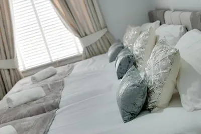 a white bed with pillows on it with a window at RST Rodney Street in Liverpool