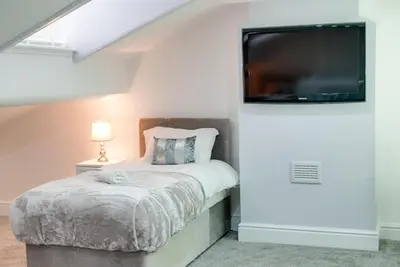 a bedroom with a bed and a flat screen tv at RST Rodney Street in Liverpool