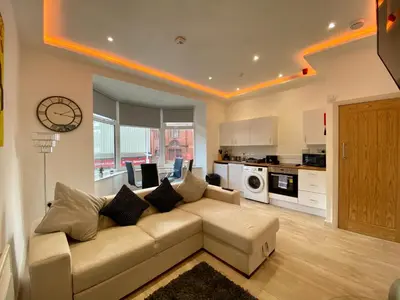 a living room with a couch and a kitchen at Princess Theatre Beach View Apartments by Blackpool Service Apartments in Blackpool