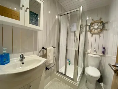 a bathroom with a sink and a shower and a toilet at Princess Theatre Beach View Apartments by Blackpool Service Apartments in Blackpool