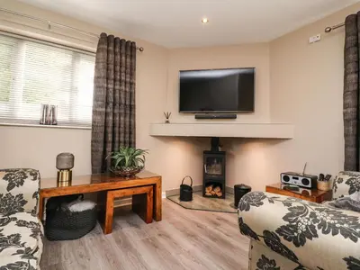 a living room with two chairs and a fireplace at Kilmory Lodge in Poulton le Fylde