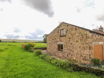 an old stone house in a grassy field at The Croft in Chorley