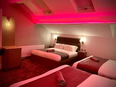 a room with two beds and a pink light at Salt-Rock in Blackpool