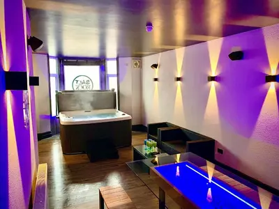 a room with a bed and a table and purple lights at Salt-Rock in Blackpool