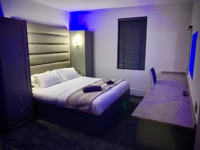 a bedroom with a bed in a room with purple lights at Salt-Rock in Blackpool