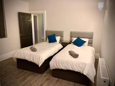 a bedroom with two beds with blue pillows on them at Salt-Rock in Blackpool