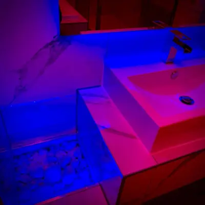 a bathroom with pink and blue lights on a sink at Salt-Rock in Blackpool