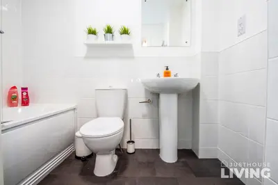 a white bathroom with a toilet and a sink at NEW Spacious Modern Townhouse Sleeps 12 Free Parking in Liverpool