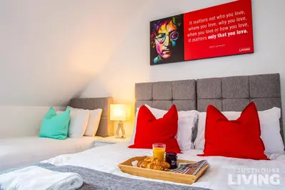 a room with a bed with red and blue pillows at NEW Spacious Modern Townhouse Sleeps 12 Free Parking in Liverpool