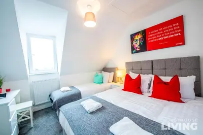 a bedroom with two beds with red pillows at NEW Spacious Modern Townhouse Sleeps 12 Free Parking in Liverpool