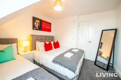 a bedroom with two beds and a mirror at NEW Spacious Modern Townhouse Sleeps 12 Free Parking in Liverpool