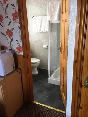 a bathroom with a toilet and a glass door at Kingscliff in Blackpool