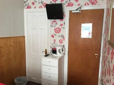a room with a door with a tv on the wall at Kingscliff in Blackpool