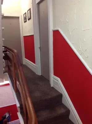 a hallway with red and white walls and stairs at Lindisfarne Holiday Apartments - Families & Couples Only in Blackpool