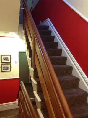 a staircase in a building with red walls at Lindisfarne Holiday Apartments - Families & Couples Only in Blackpool