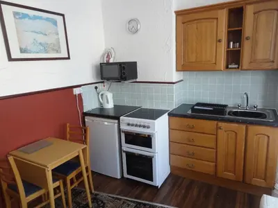 a small kitchen with a stove and a sink at Lindisfarne Holiday Apartments - Families & Couples Only in Blackpool