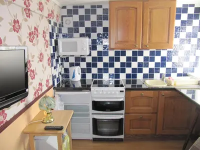 a small kitchen with a stove and a sink at Lindisfarne Holiday Apartments - Families & Couples Only in Blackpool