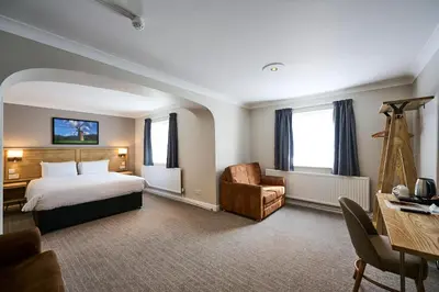 a hotel room with a bed and a chair and a desk at Red Lion, Wigan by Marston's Inns in Rufford
