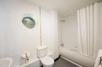 a white bathroom with a toilet and a bath tub at Red Lion, Wigan by Marston's Inns in Rufford