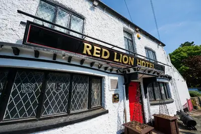 a red lion hotel sign on the side of a building at Red Lion, Wigan by Marston's Inns in Rufford