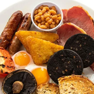 a plate of food with eggs sausage bread and beans at Red Lion, Wigan by Marston's Inns in Rufford