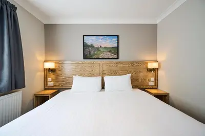 a bedroom with a large white bed with two pillows at Red Lion, Wigan by Marston's Inns in Rufford