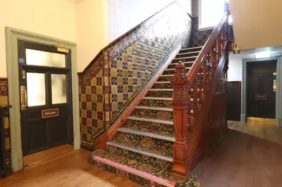 a staircase in a building with a wooden stair case at The Bridge Inn Hotel in Bolton