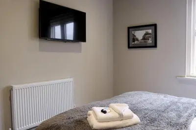 a bedroom with a bed with a tv on the wall at The Bridge Inn Hotel in Bolton