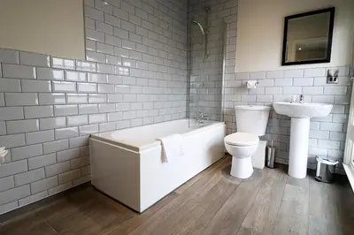 a bathroom with a tub and a toilet and a sink at The Bridge Inn Hotel in Bolton