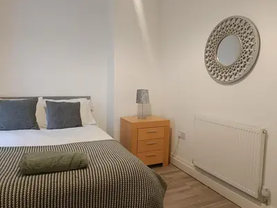 a bedroom with a bed and a mirror on the wall at Parton Residence in Liverpool