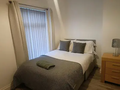 a bedroom with a large bed with a window at Parton Residence in Liverpool