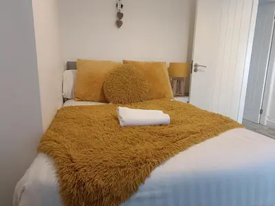 a bed with a brown blanket and pillows at Parton Residence in Liverpool