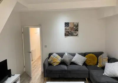 a living room with a black couch in a room at Parton Residence in Liverpool