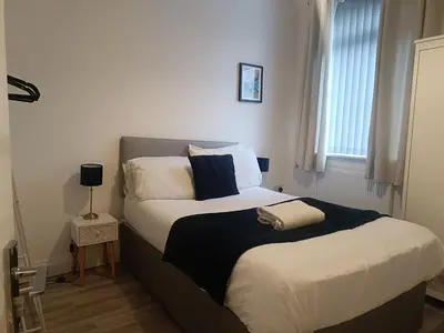 a bedroom with two beds with white and blue pillows at Parton Residence in Liverpool