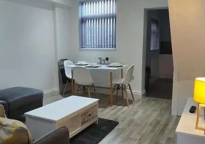 a living room with a white table and chairs at Parton Residence in Liverpool
