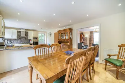 a kitchen and dining room with a wooden table and chairs at Hillberry in Grange Over Sands
