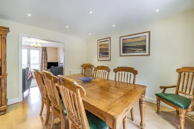 a dining room with a wooden table and chairs at Hillberry in Grange Over Sands